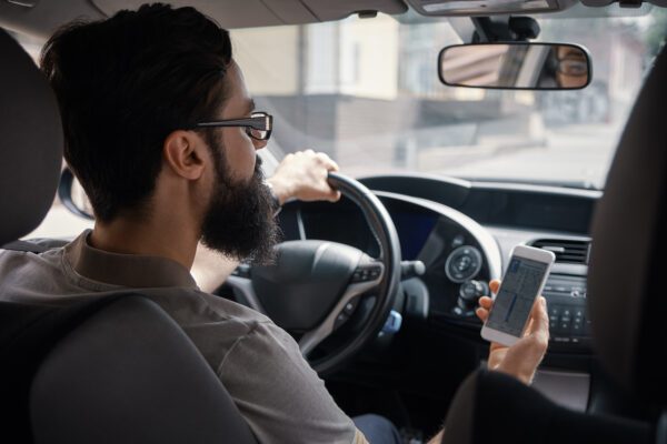 People tracking - everything you need to know man using mobile phone while driving 2021 08 26 15 55 13 utc 600x400 - people tracking - everything you need to know