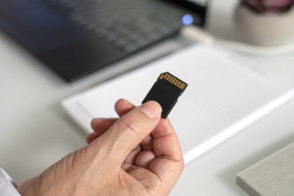 Topo GPS - What is it anyway? man holding an SD card to insert into a laptop 2022 11 08 07 45 05 UTC 601x400 - Topo GPS - What is that anyway?