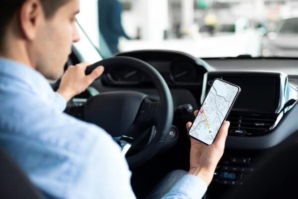 Locate cars for free with GPS - does it even work? young man using gps service navigation app on smar 2022 12 16 09 24 28 utc 600x400 - locate cars with GPS for free - does it even work?