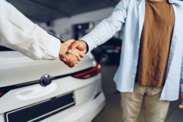 Selling a car - How a GPS tracker can help you car seller and buyer handshake at car dealership a 2021 09 03 03 02 30 utc 600x400 - Selling a car - How a GPS tracker can support you