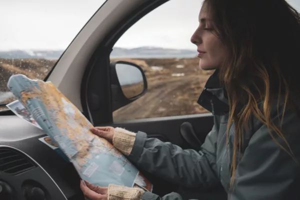 Road trip by car - experience unforgettable adventures Iceland young woman in car looking at map 2022 12 16 22 05 18 UTC 600x400 - Road trip by car - Experience unforgettable adventures